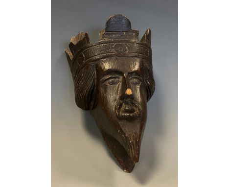 A 19th century oak architectural boss, carved as the head of a Medieval king, 16cm long 