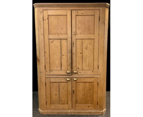 A Large Victorian pine corner cupboard, floor-standing, moulded cornice, pair of panelled doors to top enclosing three tiers 