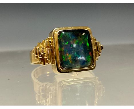 A mid 20th century black opal ring, rectangular cabochon opal approx 10mm x 8mm flashing strong green, red, blue, violet and 
