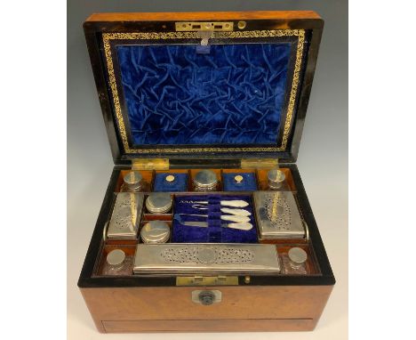 A Victorian walnut vanity box, hinge lid, fitted interior with a mix of hallmarked silver and silver plated topped scent bott