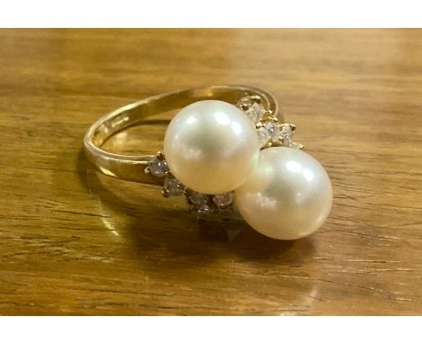 A diamond and pearl dress ring, two creamy white cultured pearls, approx 7mm diameter, set between two clusters of six round 