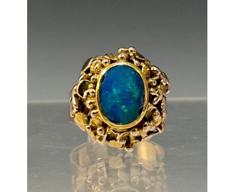 An blue green opal ring, the opal approx 10mmx 7mm, flashing strong blue, green and violet colour play, rolled collar above t