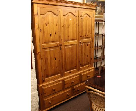 Pine wardrobe having two arched panel doors above five drawers, 154cm wide
