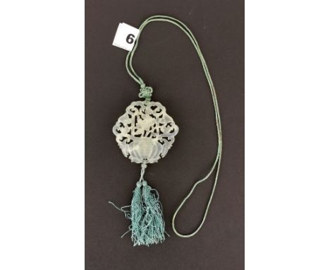 A lovely Chinese carved jade amulet on a faded green silk cord, Dia. 6cm.