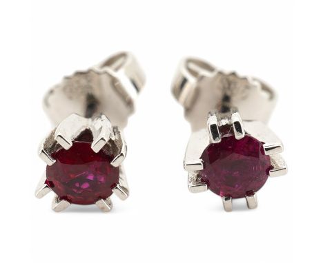 A modern pair of 585 white metal and solitaire ruby set ear studs, overall diameter 5mm, gross weight 1.4 grams. Condition - 