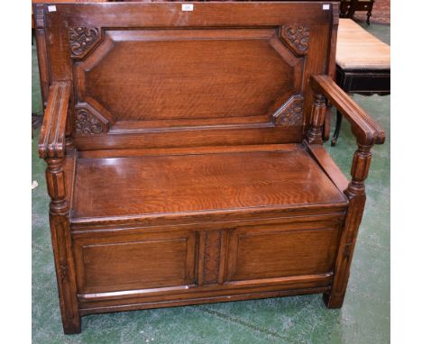 An oak monk's type bench, rectangular top metamorphosing into the bench back, hinged seat, 107cm wide