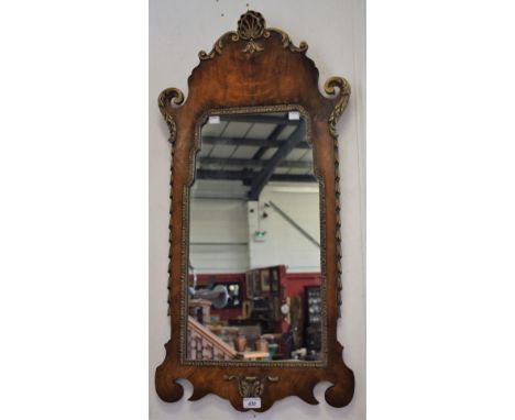 A George III style walnut and parcel 'gilt' vauxhall looking glass, shaped rectangular mirror plate crested by a shell and sc