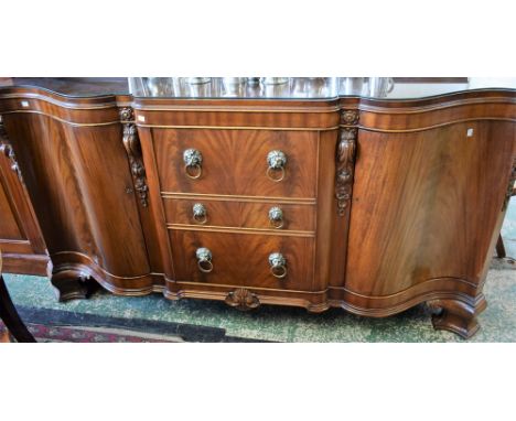 A Victorian style mahogany serpentine break centre sideboard, shaped top with stepped half gallery above three drawers, the c