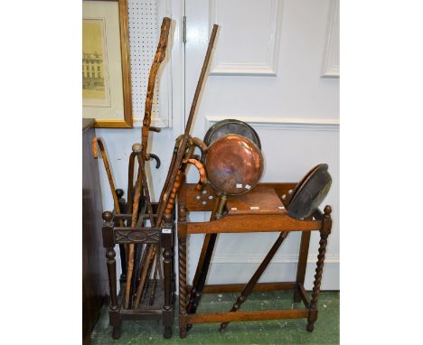 A 20th century oak walking stick/umbrella stand, containing an assortment of sticks; another, similar, larger, containing cop