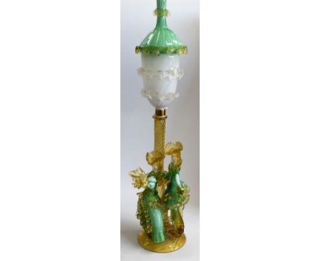A Murano Venetian Glass Company lamp, formed as a dandy and his beau, the figures in green cased over white and amber, with a