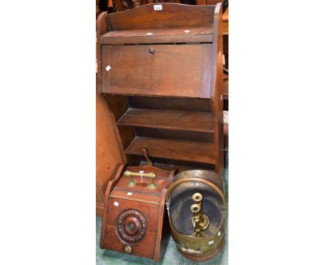 An early 20th century oak student`s desk, fall front over three shelves; a brass helmet coal scuttle; a late 19th century mah