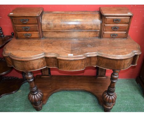 A late 19th/early 20th century walnut side table, the shaped superstructure centred by a hinged cover flanked by small drawer