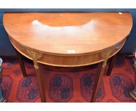 An early 20th century parcel-gilt walnut demi-lune side table