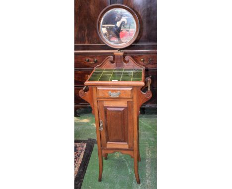 An early 20th century mahogany shaving/washstand, adjustable circular mirror above a rectangular tile top a drawer and panel 