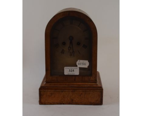 A mantel clock, the silver arched dial with Roman numerals, fitted a movement, striking on a bell, in a burr maple case, 24.5