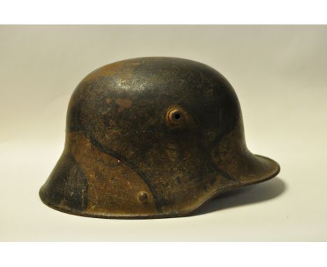 A German steel helmet, with camouflage painted decoration (lacks chin strap)  Condition report ReportPlease note that owing t