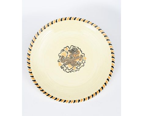 A Crown Ducal charger designed by Charlotte Rhead, pattern no.3150, tubeline decorated with a Manchu dragon, in yellow and br