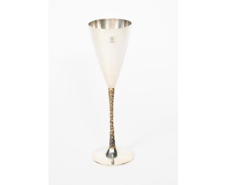 A Stuart Devlin silver gilt champagne flute, model no.500, flaring conical body with textured gilt stem and flaring foot, the