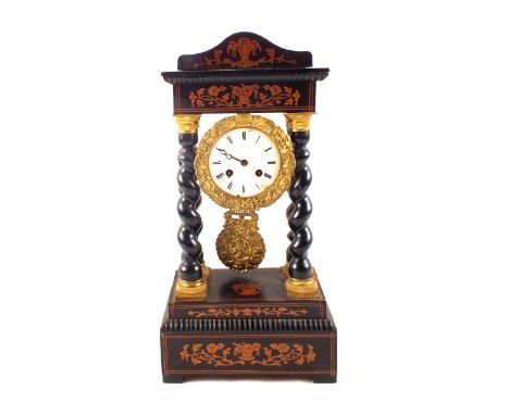 A 19th Century French Empire style ebonised mantel clock with floral inlays supported by four barley twist columns
