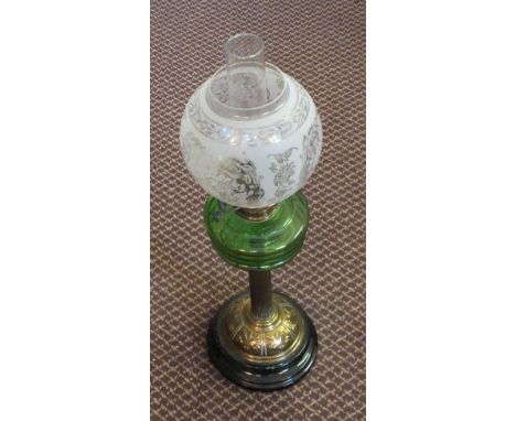 A Brass column oil lamp with green glass font and etched globe