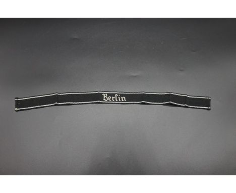 A German 'Berlin' cuff title,&nbsp;with silver thread embroidered detail and inscribed on paper label, 45cm long.&nbsp; 