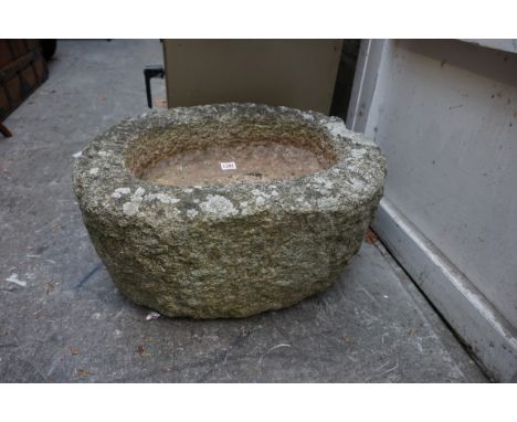 A small old granite oval trough, 27cm high x 57cm wide x 10cm internal depth. 