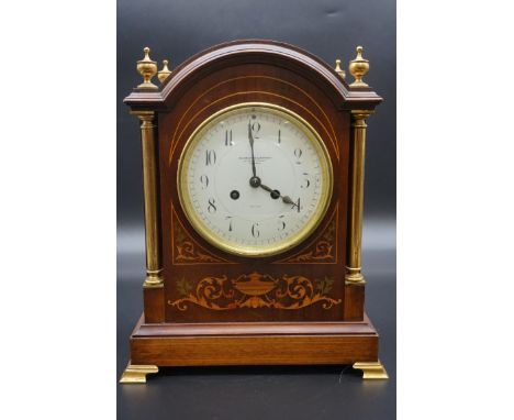 An Edwardian mahogany and inlaid mantel clock,&nbsp;the 5 1/2in circular enamel dial inscribed 'Goldsmiths Company', 35cm hig