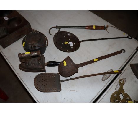 A fishing gaff with turned wooden handle, two skimmers, a cast iron ladle, a glue pot and a flatiron on stand 