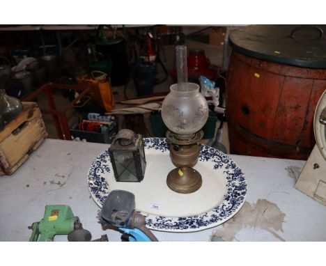 An oval blue and white meat plate; a brass oil lamp and a candle lantern