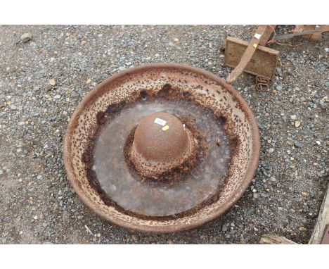 A circular cast iron pig trough
