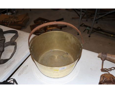 A vintage brass jam pan with iron loop handle