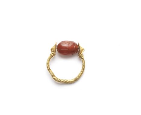  An Etruscan gold and carnelian scarab swivel ring Circa 4th Century B.C.The scarab modelled naturalistically, carved on the 