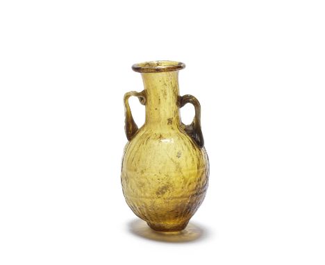  A Sidonian amber glass amphoriskos Circa 1st Century A.D.The ovoid body blown in a two-part mould, with a central band of sc