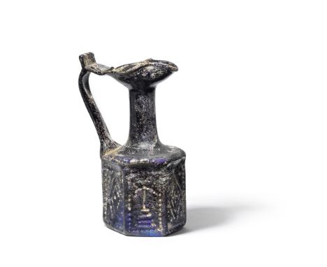  A Byzantine amber-brown glass hexagonal jug  Late 6th - early 7th Century A.D.The body mould-blown with six decorative panel