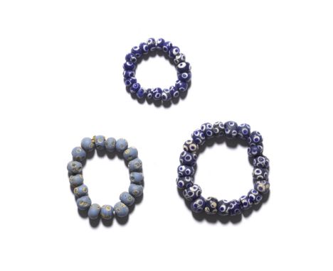  A collection of Phoenician glass 'eye' beads Circa 6th-2nd Century B.C.Strung as three bracelets, the largest with twenty-on