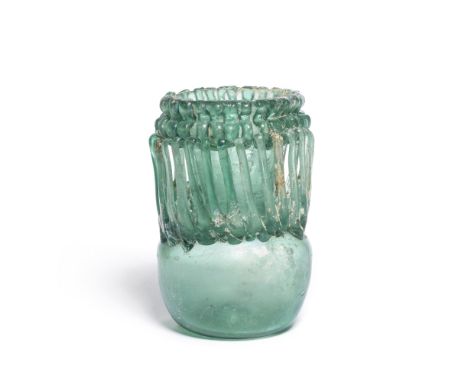  A late Roman - early Byzantine deep turquoise-green glass jar  Circa 6th Century A.D.The funnel neck with tooled horizontal 