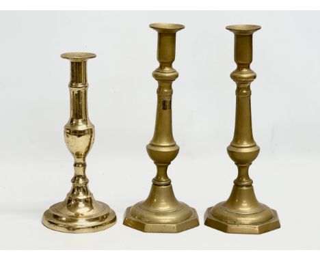 A pair of tall Victorian brass candlesticks, with another Victorian brass candlestick. 24cm. 28cm. 