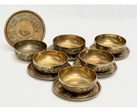 A 12 piece Early/Mid 20th Century Chinese brass bowls and saucers. With embossed seal marks and dragons. Bowls 11.5x4cm. Sauc