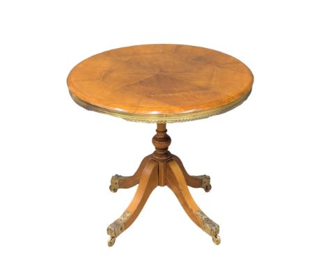 A brass mounted pedestal lamp table on lion paw feet. 60x54cm 