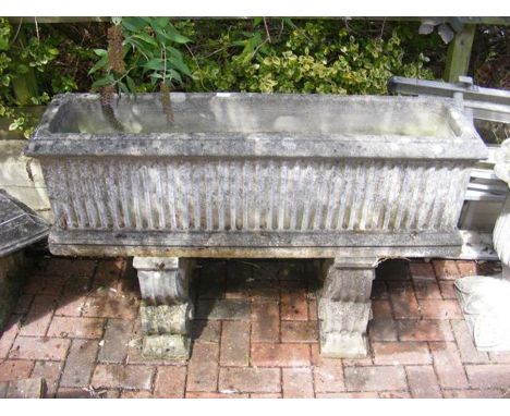 A large trough garden planter on double plinth