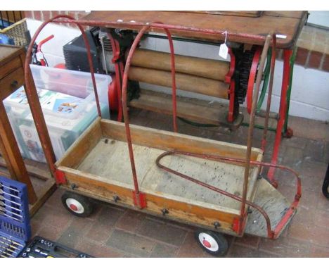 A vintage pull along child's wooden wagon with metal roll cage