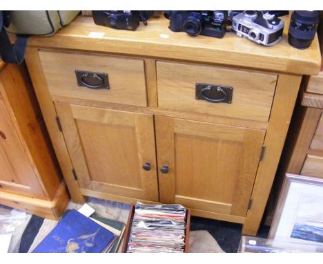 A light oak utility cupboard consisting of two drawers and a two door cupboard - width 85cms