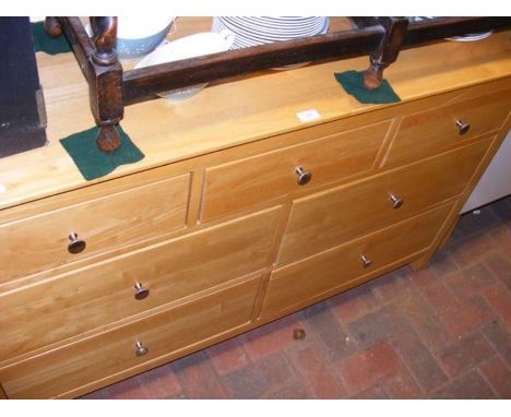 A contemporary light wood sideboard, consisting of seven drawers - width 138cm 
