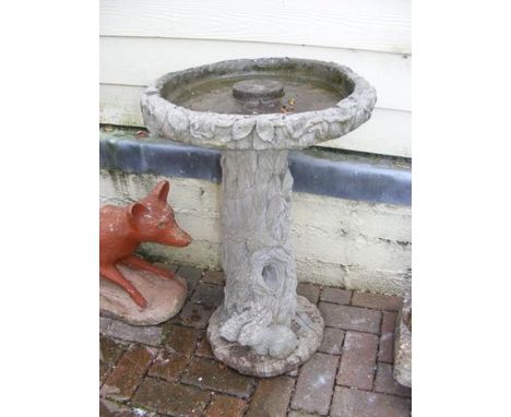 A moulded tree trunk bird bath