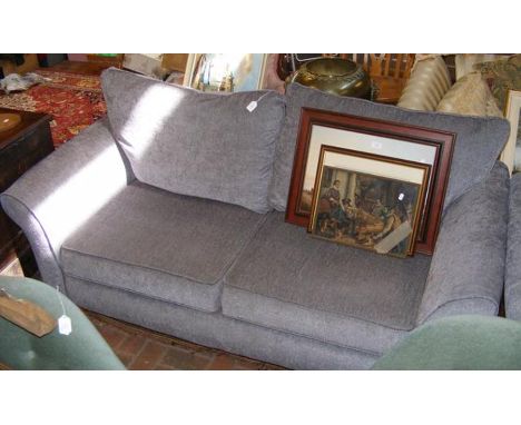 A modern three seater settee upholstered in light grey material 
