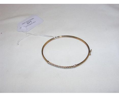 A diamond mounted 9ct gold bangle 