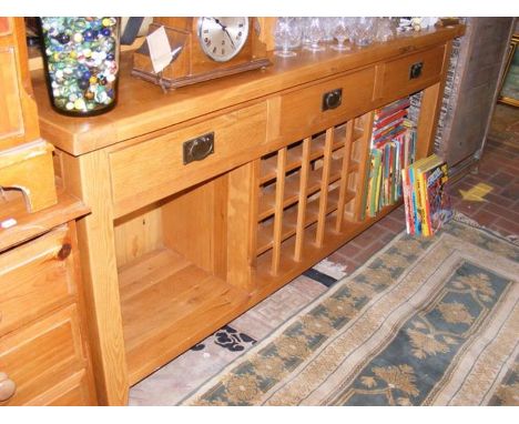 A contemporary light oak kitchen side table with central wine rack - width 180cms