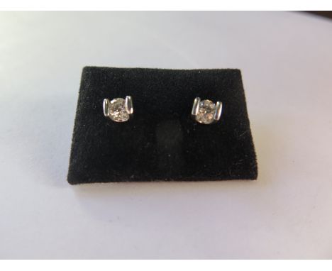 A pair of diamond earrings in platinum settings,  good condition 