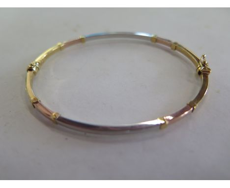 A 8ct yellow gold and white metal bangle - 55mm x 65mm with sprung hinge, approx 2.9 grams, in generally good condition, mino