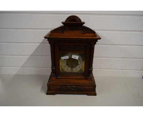 WALL CLOCK IN ORNATE WOODEN FRAME WITH COLUMNS FLANKING SILVERED DIAL